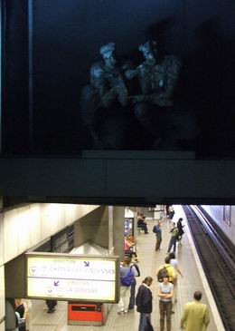 та же станция (педики сидят над лестницей и окружают вход в метро)