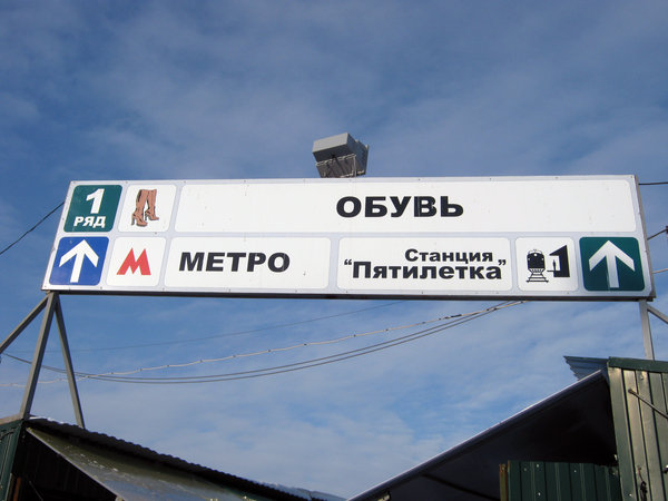 Указатель прохода к станции метро Кировская на рынке.