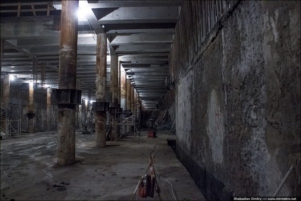 На стене в грунте, что на фотографии справа видны многочисленные сколы бетона вплоть до арматуры. По словам строителей, стену в грунте выполнили некачественно, в результате чего она накренилась вовнутрь котлована.